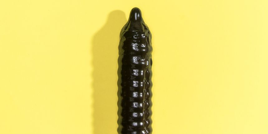 Zwarte dildo op gele achtergrond - lovesexshop.be Sexshop
